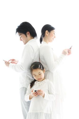 가족(아빠, 엄마, 딸)이 각각 휴대 전화를 보고 있다.
